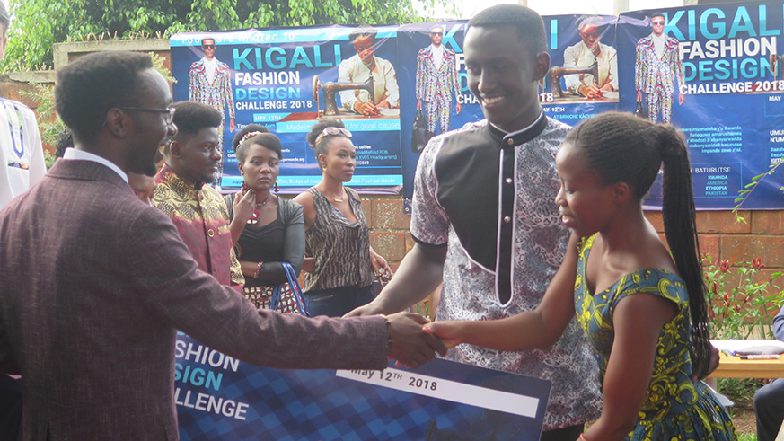 Justin Sunday (left) the event organiser, hands over the cheque of Rwf100, 000 to Florence Ingabire (right), after winning the contest .