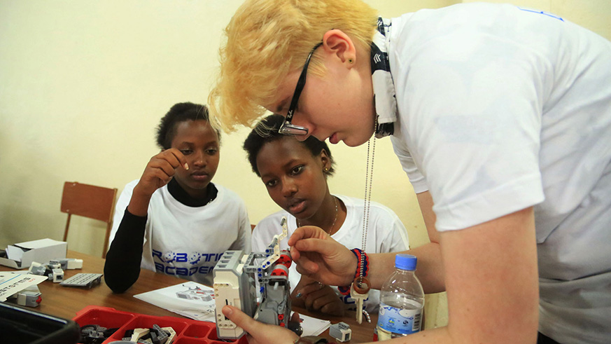 An instructor shows students how to go about their exercise during the launch of the inaugural Robotics Camp Rwanda in Kigali.  Photo by Sam Ngendahimana.