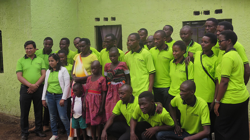 Mukarubibi and grandchildren pose for a photo with Sahasra staff in front of her new home.Eddie Nsabimana.