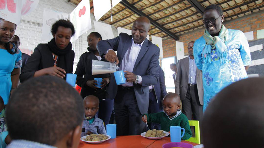 Prime Minister,  Edouard Ngirente giving milk to some of kids who are raised in Bigogwe kindergarten under Early Childhood Development initiative. (Photos by Regis Umurengezi)
