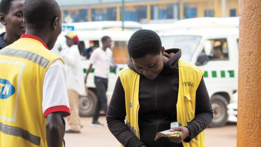 A mobile money vender transacts business on a cell phone in downtown Kigali. File.