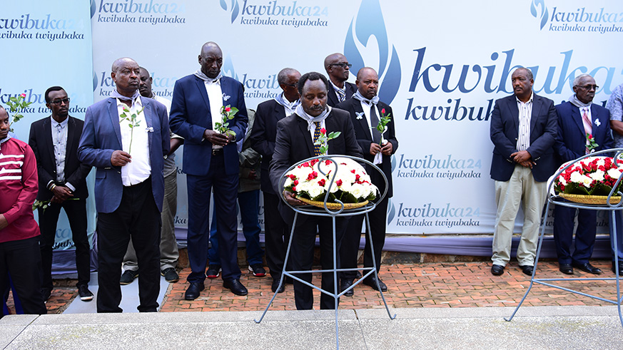 Theogene Gakuba Kayiranga, the president of the Kassapard association laying wreath on the graves as other mouners look on. (Frederic Byumvuhore)