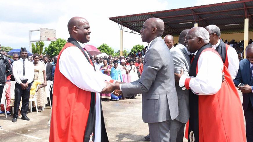 Minister Kaboneka shaking hands with Samuel Mugisha Mugiraneza, the new Bishop of Shyira Diocese. Regis Umurengezi