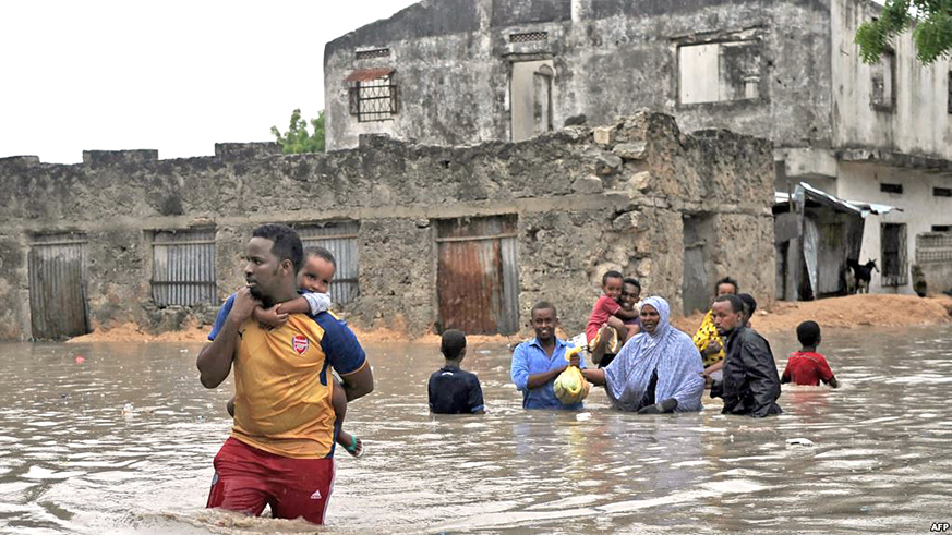 People evacuate their homes through waist-deep flood water in Mogadishu. Net photo