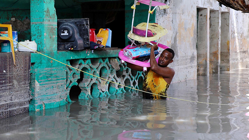 A man evacuates property from a flooded house. Net photo.