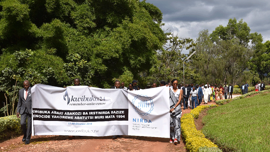 NIRDA board chairman Steven Mutabazi with other staff members hold a banner as they walk to remember the victims of the 1994 Genocide against the Tutsis.
