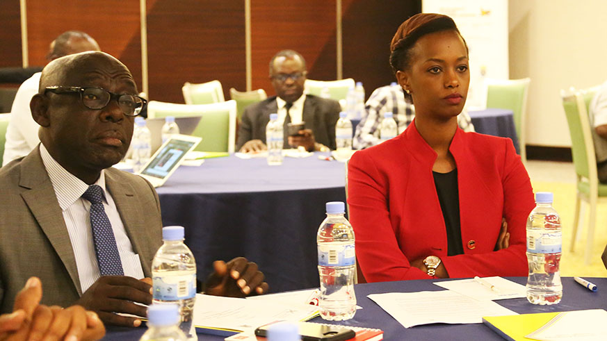 Dennis Karera, the Vice Chair of the East Africa Business Council, and Patience Mutesi, the country director for TradeMark East Africa, follow a presentation during the meeting in Kigali yesterday. Sam Ngendahimana.