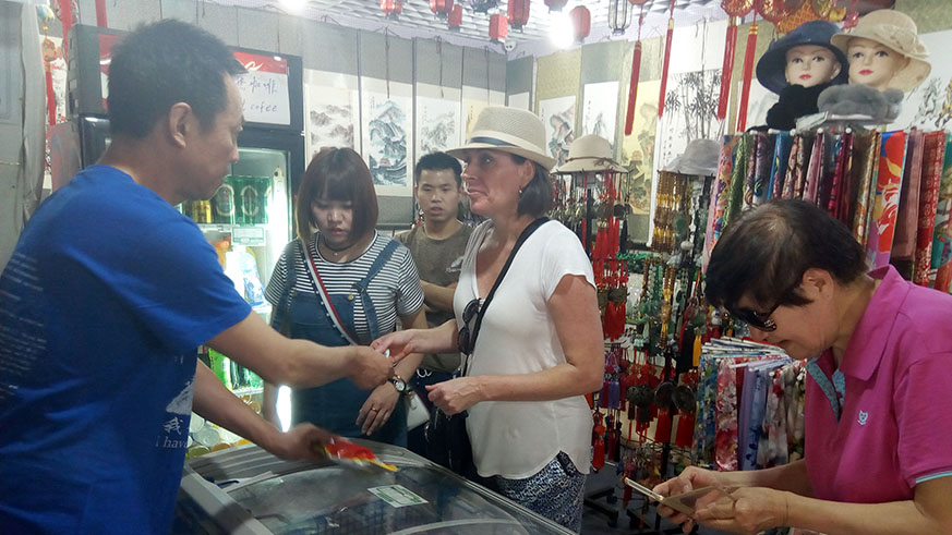 Tourists buy Chinese products after reaching the last stage of the Great Wall. Anne Dushimimana.
