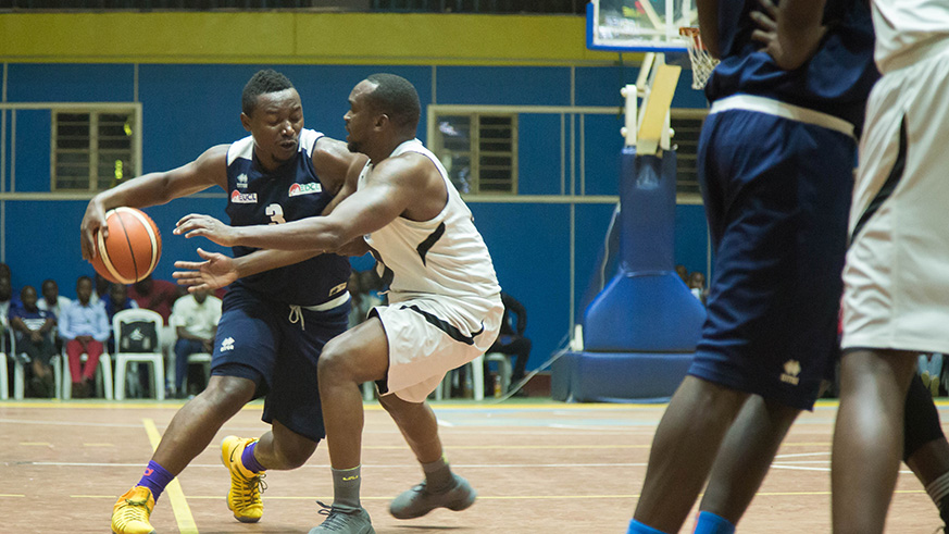 REG's Benjamin Mukengerwa (with the ball) tries to drible past Patriots' Pascal Karekezi on Sunday night at Amahoro stadium. (Nadege Imbabazi)