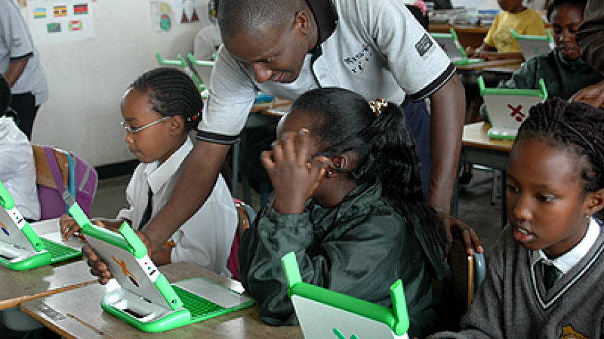 A teacher guides pupils on how to use OLPC computers. 
