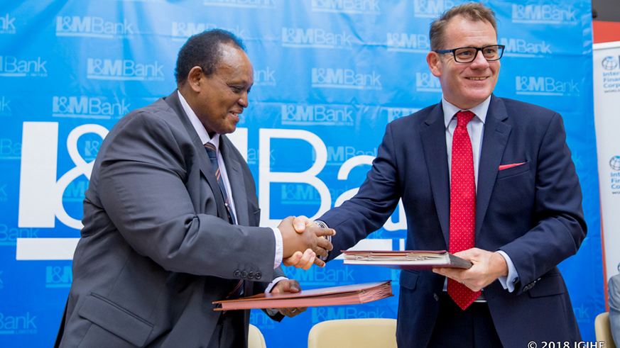 Robin Bairstow, Chief Executive Officer of I&M Bank Rwanda and Oumar Seydi, IFC Regional Director for Africa shake hands after the signing of the deal.