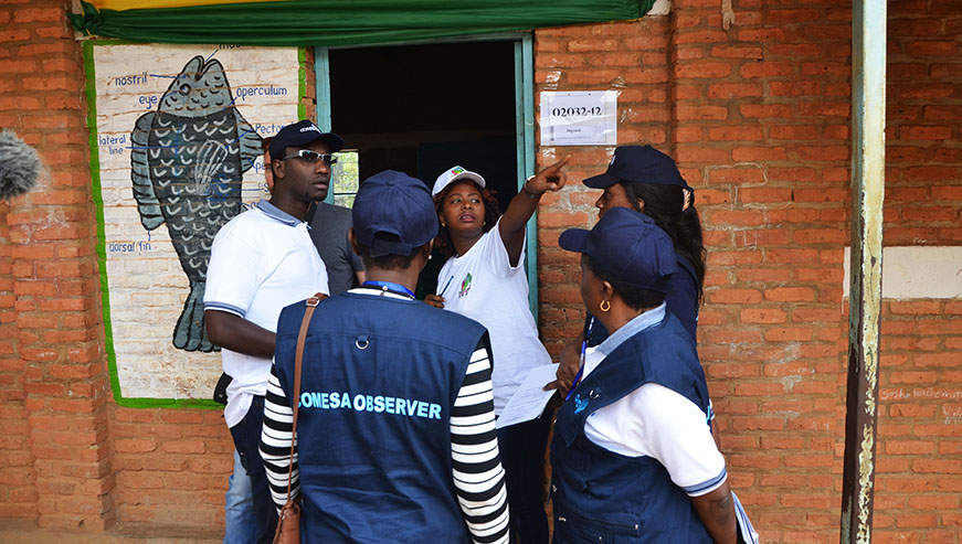 An electoral volunteer talks to COMESA observers at Groupe Scolaire Kimironko II polling station during Presdential elections in Gasabo District last year. Sam Ngendahimana.