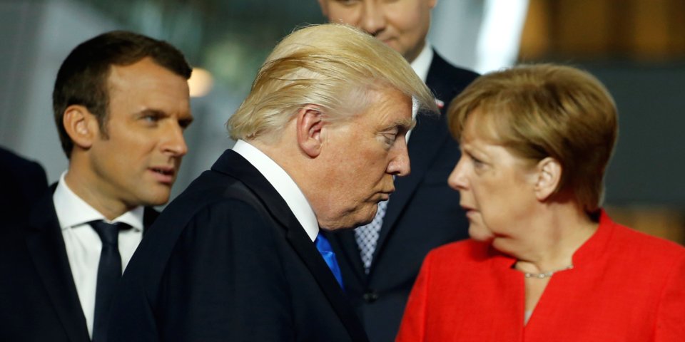 U.S. President Donald Trump (C) walks past French President Emmanuel Macron (L) and German Chancellor Angela Merkel on his way to his spot for a family photo during the NATO summit at their new headquarters in Brussels, Belgium May 25, 2017. / Internet photo