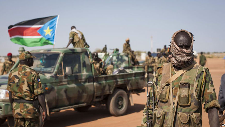 A South Sudanese government soldier stands with others near their vehicles, after government forces retook from rebel forces the provincial capital of Bentiu, in Unity State, South Sudan, Jan 12, 2014. Net.