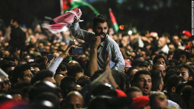 Jordanian protesters shout slogans and raise a national flag during a demonstration outside the Prime Minister's office in the capital Amman late on Friday. / Internet photo