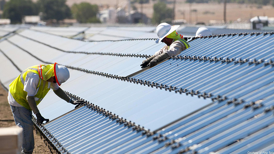 Workers inspect solar panels. Net.