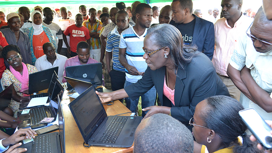 State Minister Mukabaramba is shown how technology is used to help families in Kayonza District easily get health insurance. Jean de Dieu Nsabimana