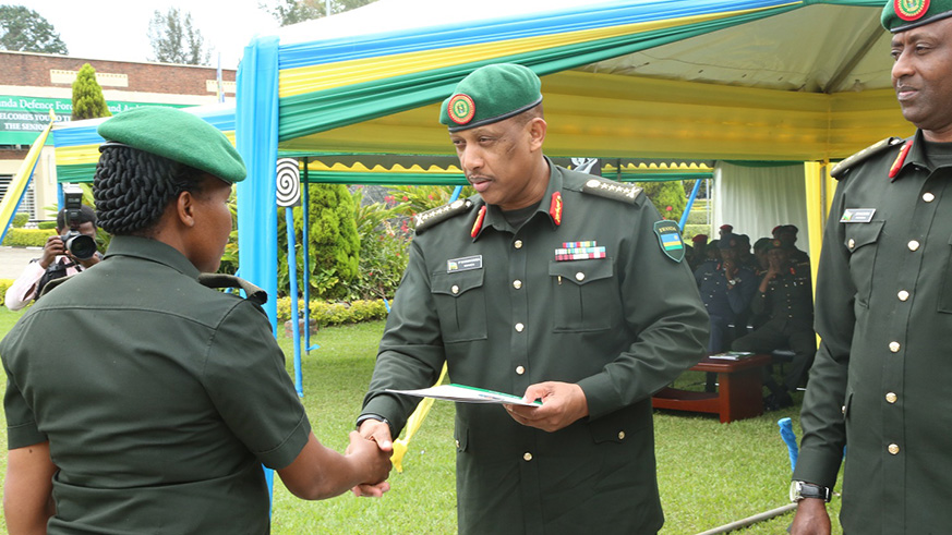 Gen Nyamvumba awarding with the passed staff college certificate one of RDF female officer who made it at the Senior Command and Staff Course Intake six. Regis Umurengezi