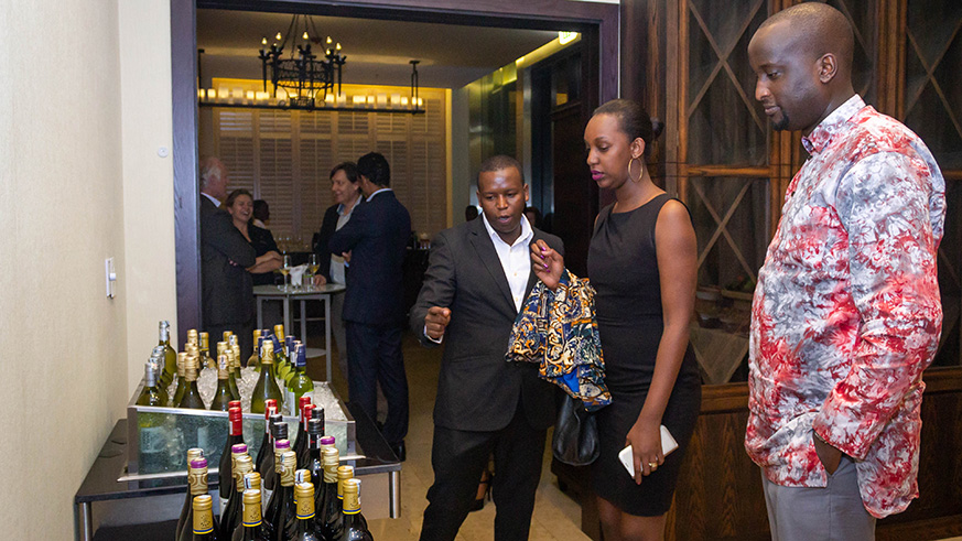 A couple is being shown the different types fo wines during the wine testing event