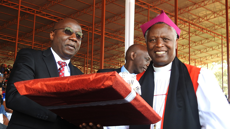 New Archbishop Dr Laurent Mbanda hands a gift to Prime Minister Edouard Ngirente. / Frederic Byumvuhore