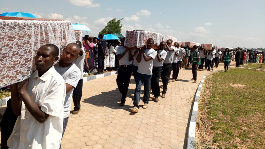 People carry the coffins as Gisagara district relocated over 43,000 remains of the 1994 genocide againts the Tutsi to a new memorial.