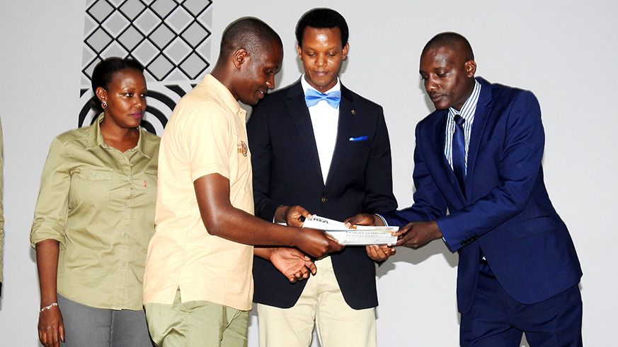 Emmanuel Nsabimana, Head of customer care and Tourism Regulations Division at RDB hands over a certificate to a guide. Frederic Byumvuhore.