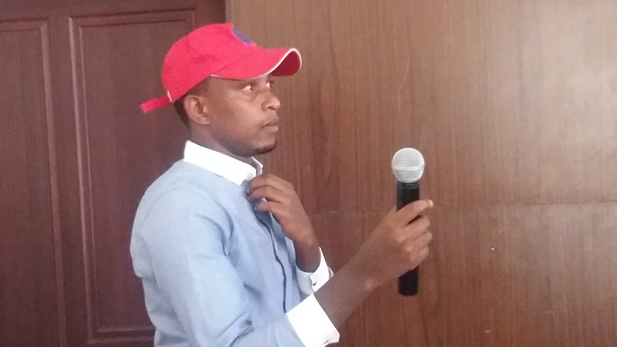 Head of PSR members at Rwandan Chapter of the Panafrican Mouvement, Sylvestre Ntirushwa holding a microphone shortly before sharing his ideas fore the election. Janvier Nshimyumukiza.