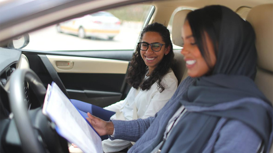 Driving instructor Ahlam al-Somali (R) reads instructions before getting ready to drive with trainee Maria al-Faraj at Saudi Aramco Driving Center in Dhahran, Saudi Arabia. / Internet photo