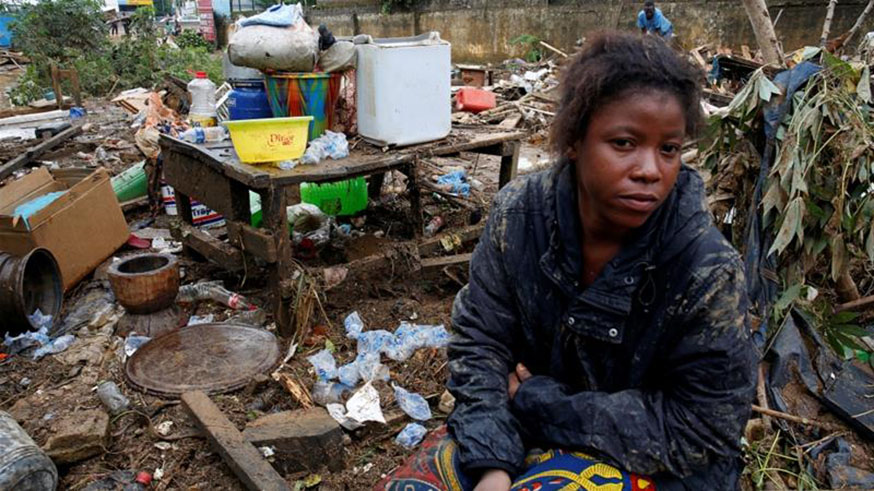 A woman sits between her belongings and the debris after flood in Abidjan. Net photo.
