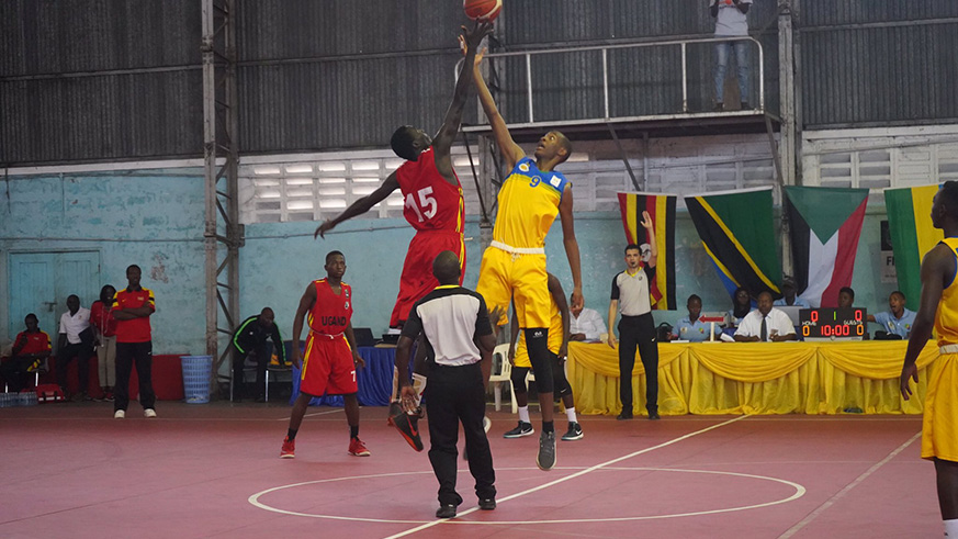 Rwanda's center Elias Ngoga vies for the ball with a Ugandan player at the kickoff yesterday at Uwanja wa Taifa indoor stadium in Dar es Salaam. / Courtesy