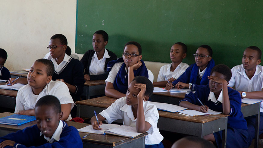 Secondary school students attentively listen to a teacher during a lesson. File.
