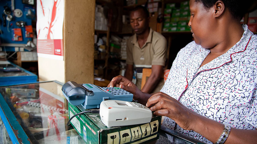 A trader uses an old electronic billing machine (EBM) in her shop in Kigali. The new reform in tax administration aims at increasing compliance. File.