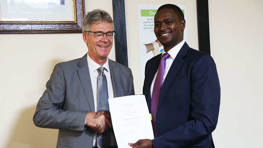 Head of Development Cooperation at the Swedish Embassy Mikael Bostru00f6m and the BRD CEO, Eric Rutabana exchange document after signing the MoU yesterday (Sam Ngendahimana)