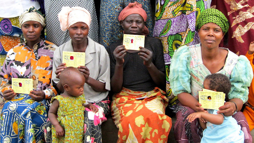Mothers pose in a group photo with their Mutuelle de Santu00e9 cards. File.