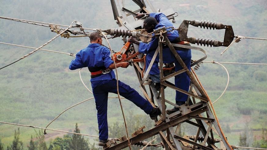 Rwanda Energy utility workers install a power line. REG says it will not be adding more power to the national grid this year. / File
