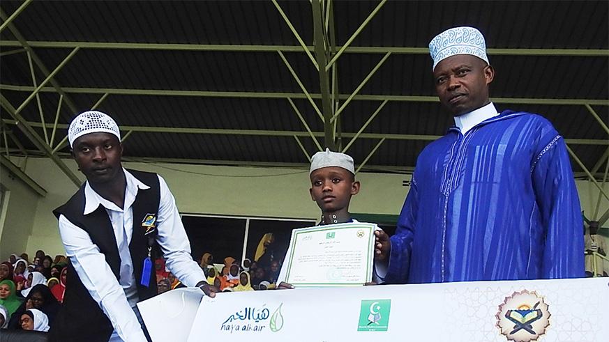 The Mufti of Rwanda, Sheikh Salim Hitimana gives a certificate to 12-year-old Al Abdi Nasir from Kenya who emerged the second.