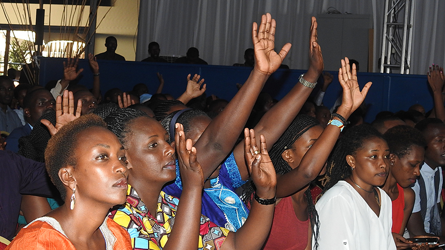 The congregation with arms raised praising God during the concert.