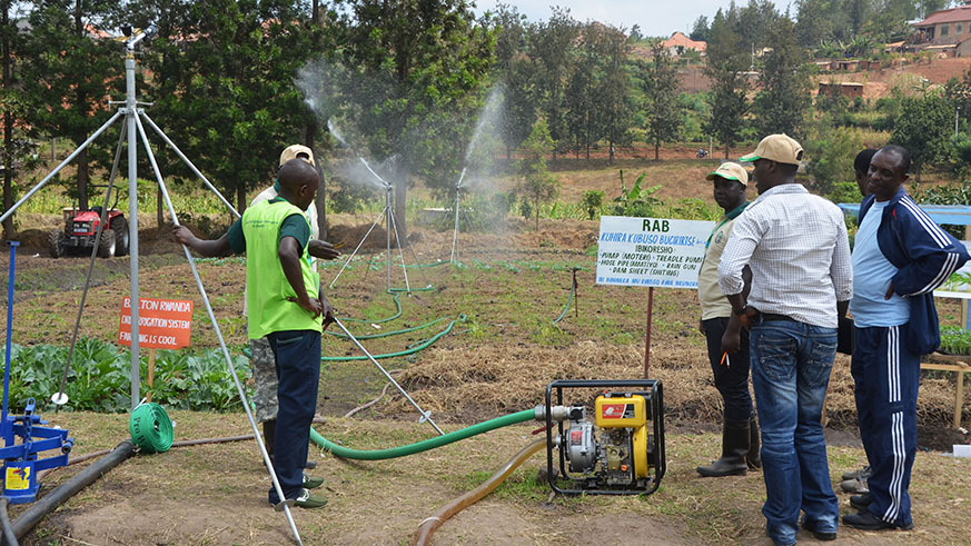 RABu2019s agric experts explain to farmers how to use irrigation equipment during a past agriculture exhibition at Mulindi. Agriculture continues to attract little funding from banks. Sam Ngendahimana.