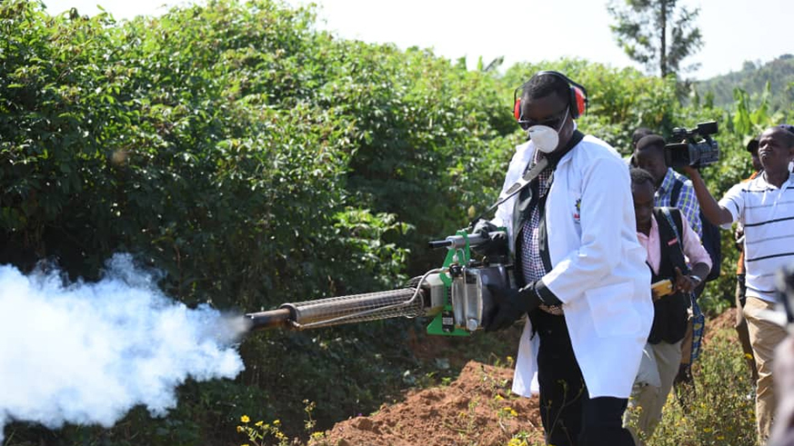 Defence minister Kabarebe uses spray against mosquitoes at the launch of the campaign in Kamonyi District. Courtesy.
