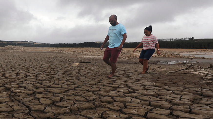 Parched: A family negotiates their way through caked mud around a dried up section of the Theewaterskloof dam near Cape Town, South Africa in Janurary. Net photo.