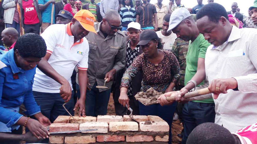 Minister Gashumba laying a foundation stone to mark the beginning of construction works for 12 health posts in the Burera District. Regis Umurengezi