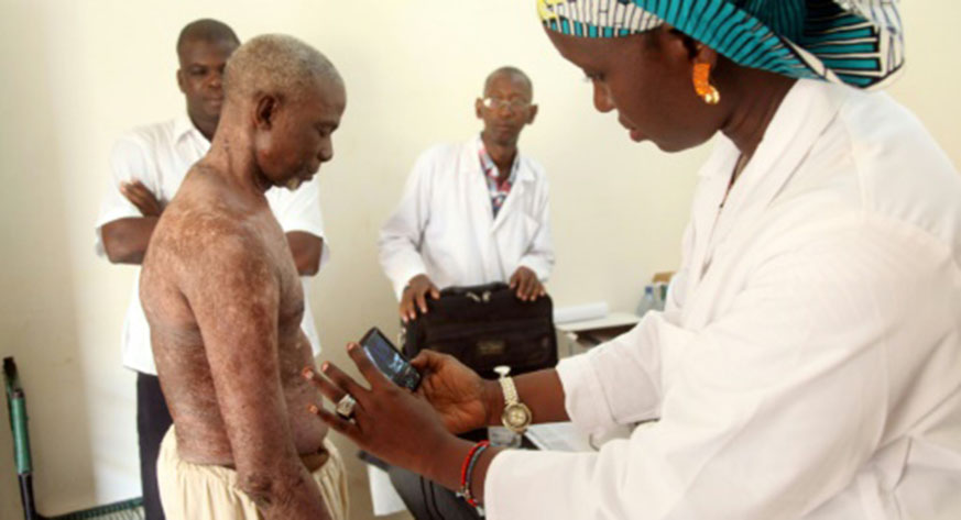 A doctor takes pictures of a manu2019s skin condition for diagnosis through an online dermatology platform in Mali. Net photo.