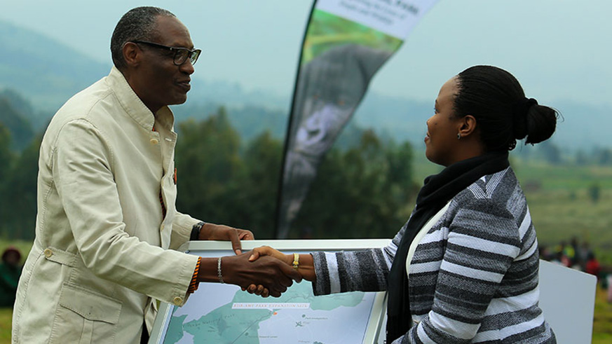 Kaddu Sebunya, the president of African Wildlife Foundation (left) hands over a map indicating 27 hectares of land to RDB CEO Clare Akamanzi which the foundation donated towards the expansion of Virunga park last year. File.