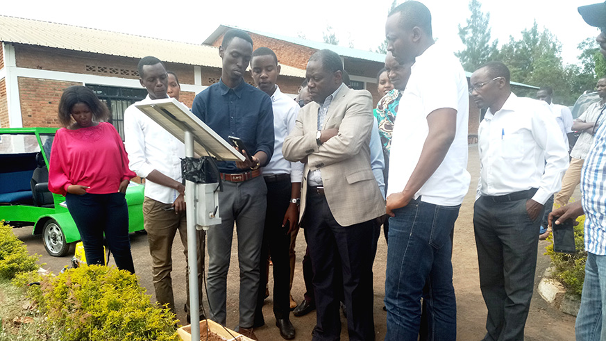 Arsene Simbi Rutangira (third left) explains how the solar-powered soil test and automatic irrigation system works. Emmanuel Ntirenganya.
