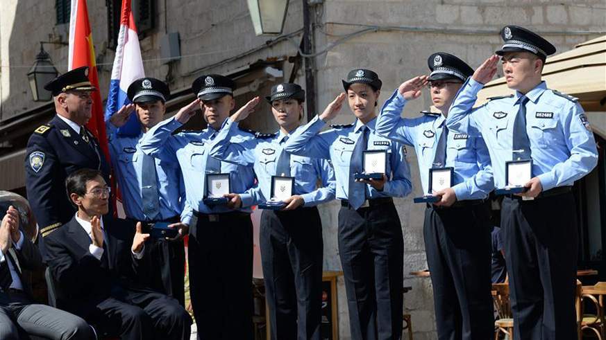 Zeljko Prsa, Deputy General Police Director of Croatia, gives police badges to Chinese police officers during the launching ceremony of joint police patrol between China and Croatia in Dubrovnik, Croatia, on July 15, 2018. Six uniformed Chinese police officers started joint patrol with their Croatian counterparts here on Sunday