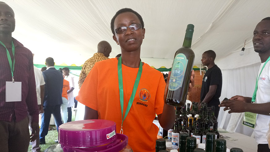 JanviÃ¨re Ingabire, the  founder of Igisura Company Ltd, shows a bottle of wine she made from stinging nettle (Igisura) during the 13th national agriculture show at Mulindi. Emmanuel Ntirenganya. 