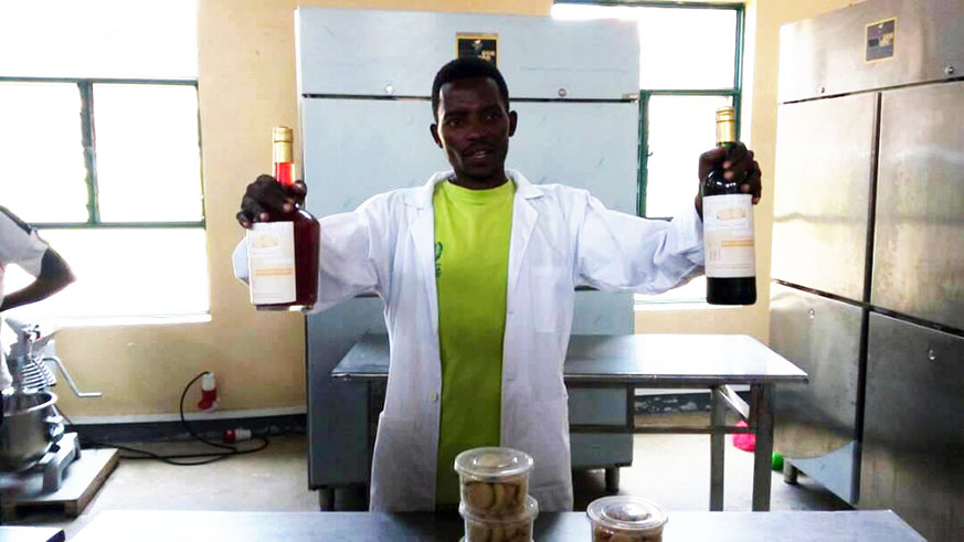 Ntezimana, a fresh graduate from IPRC-Musanze, showcasing the wine he makes from potatoes. Regis Umurengezi.                                                      