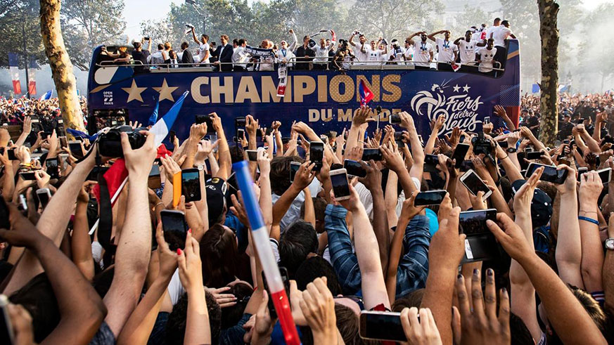 French supporters greet the Franceu2019s national soccer team players as they stand on the rooftop of a bus during a parade down the Champs-Elysu00e9e avenue in Paris, yesterday. France won 4-2 in the FIFA World Cup 2018 final against Croatia in Moscow, on Sunday. Net photo.