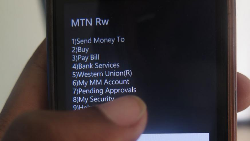 A mobile money subscriber follows procedures to send money. File.