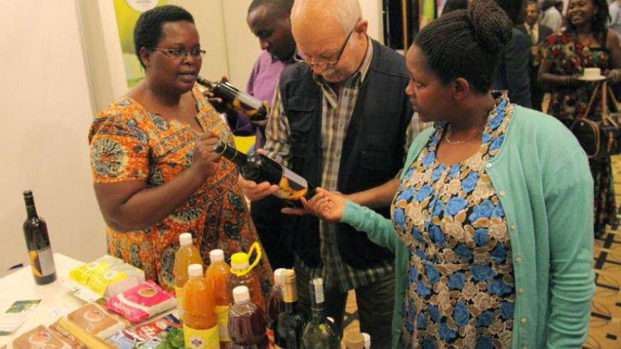 Christine Murebwayire (left) explains about her banana wine at an exhibition last year.